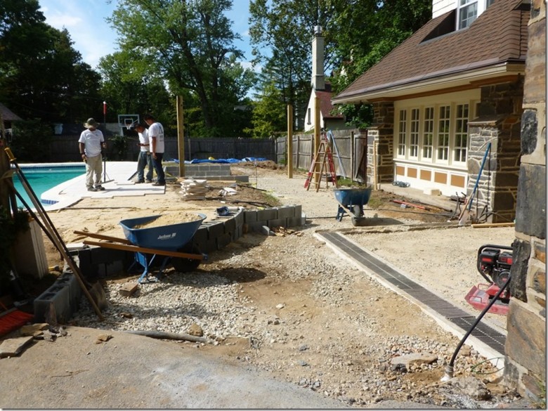 A “before” picture, our crew removed a large deck and more than 36 tons of concrete before completing the light grading and installation of the irrigation system. (Image via aardweglandscaping.com – Main Line Philadelphia PA)